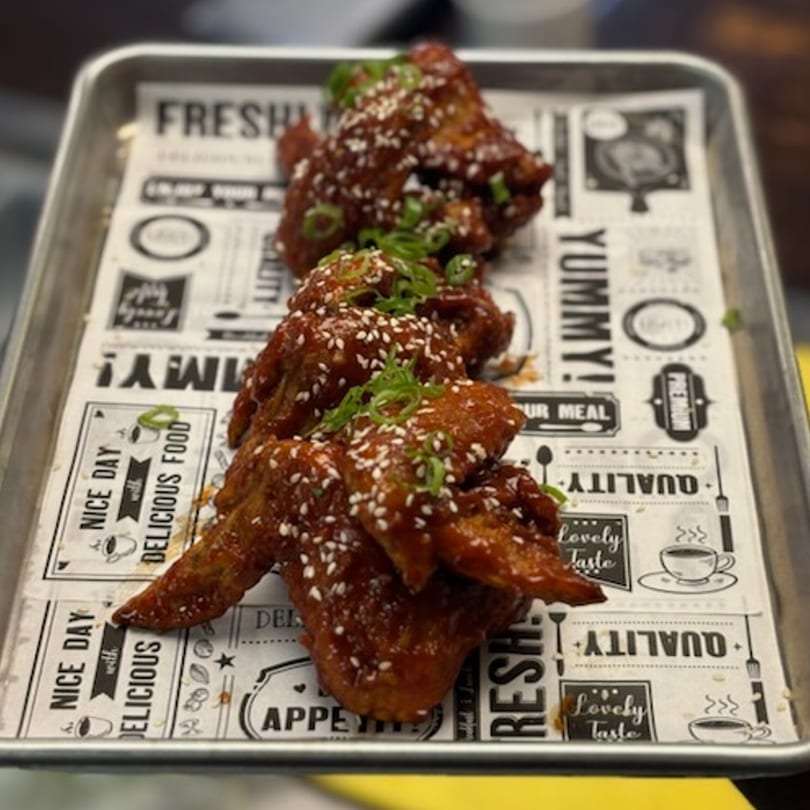 Roll-out Wingz & Eggrolls of Columbia's fried chicken wings, glazed with sauce, sesame seeds, and green onions.